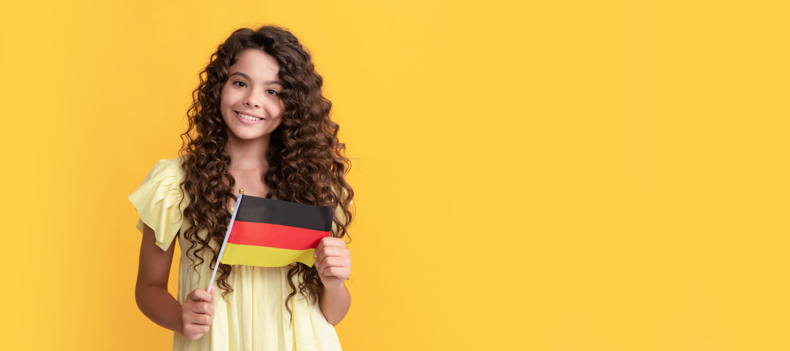 smiling kid long curly hair hold german flag, germany. Horizontal poster of isolated child face, banner header, copy space.